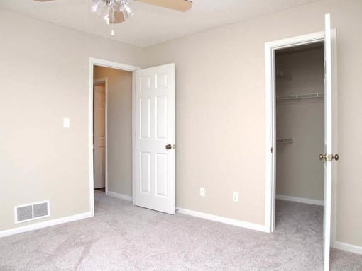 an empty bedroom with a closet and a white door