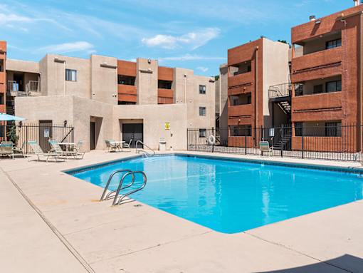 A swimming pool in front of apartment buildings.