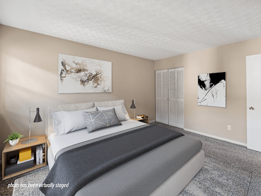 A bedroom with a large bed and two artworks on the wall.