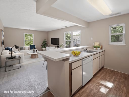 A kitchen with a white countertop and a white dishwasher.