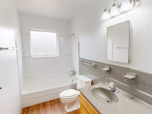 A white toilet sits next to a sink in a bathroom.