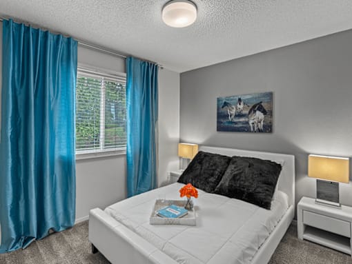 a bedroom with a white bed and blue curtains
