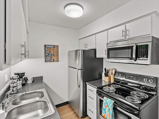 modern apartment kitchen with stainless steel appliances and sink