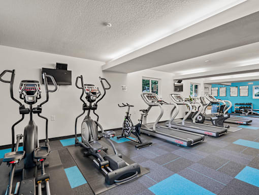 a gym with cardio machines and weights on a checkered floor