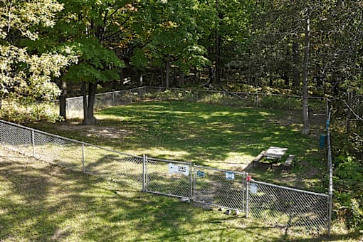A fenced area with a picnic table and a sign.