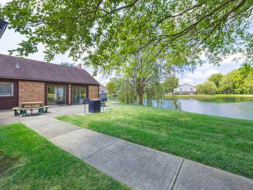 clubhouse with outdoor area and a pond in front.