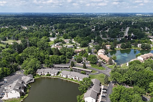 A bird's eye view of a residential area with a lake in the foreground.