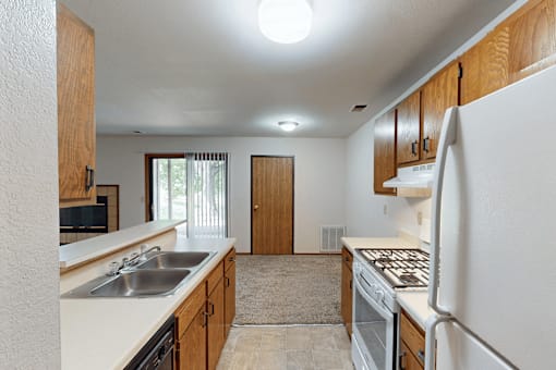 A kitchen with white appliances and wooden cabinets.