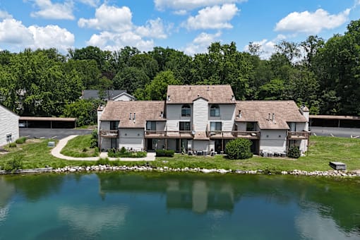 A large house with a pond in front of it.