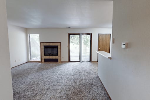 A living room with a fireplace and sliding glass doors.
