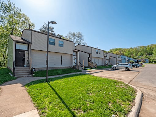 A sunny day at a residential area with houses and parked cars.