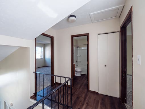 A white bathroom with a toilet, sink, and a large mirror.