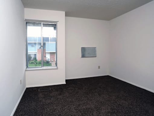 A room with a window and a wall-mounted TV.