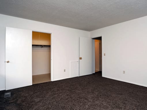 A room with white walls and a brown carpet.