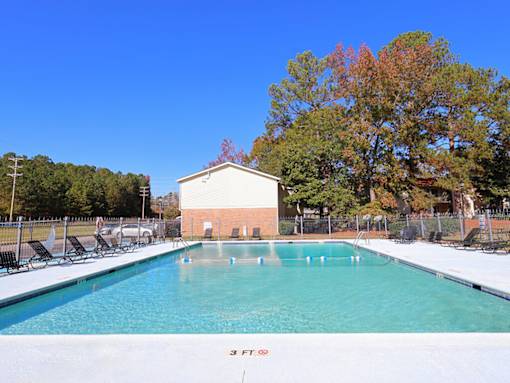 A swimming pool with a building in the background.