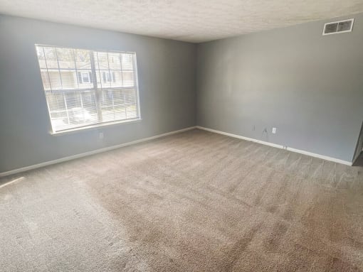 an empty bedroom with a large window