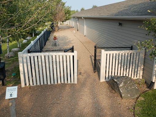 A white picket fence surrounds a house.