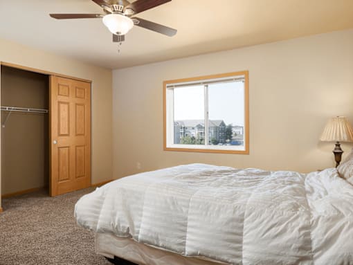 A bedroom with a large bed and a window overlooking a cityscape.