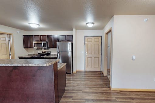 A kitchen with a refrigerator, microwave, and oven.