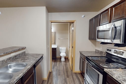 A kitchen with granite countertops and stainless steel appliances.