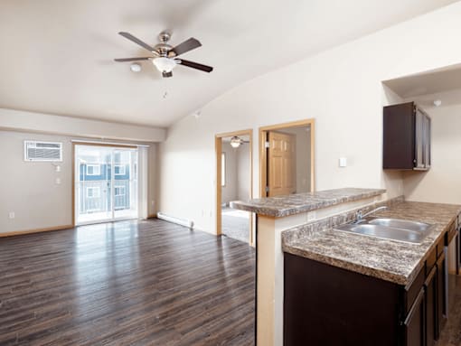 A kitchen with a fan on the ceiling and a counter top.