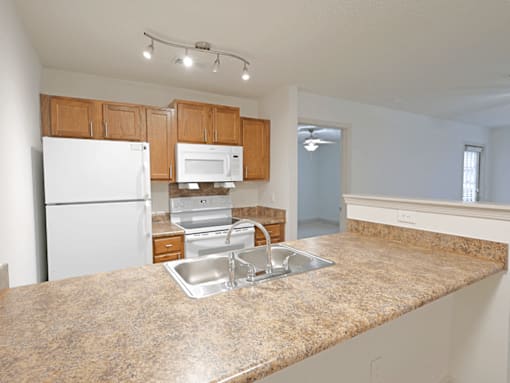 A kitchen with granite countertops and white appliances.