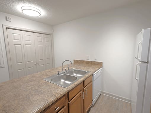 A kitchen with a sink and a refrigerator.