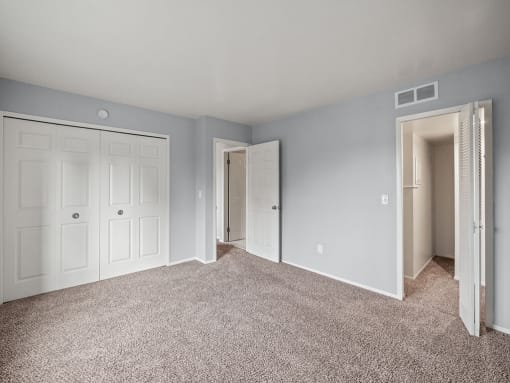 an empty bedroom with blue walls and white doors