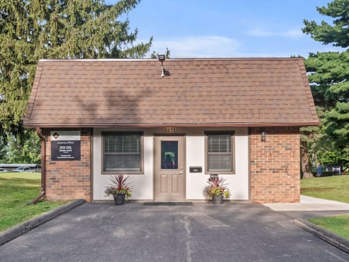 the front of a small brick building with a door