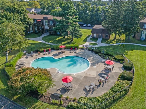 an aerial view of a swimming pool and patio with umbrellas
