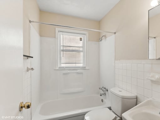 a white bathroom with a tub and a toilet and a sink