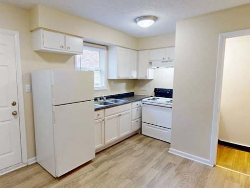 Apartment kitchen with white appliances and cabinets