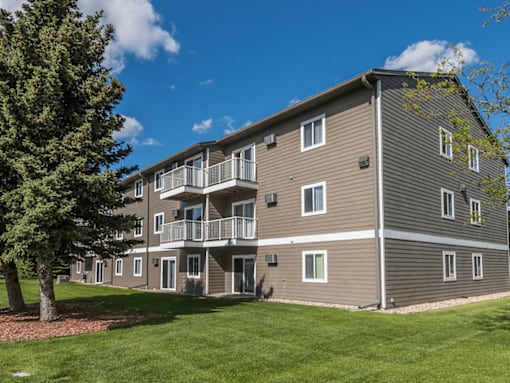 A large apartment building with a tree in front of it.
