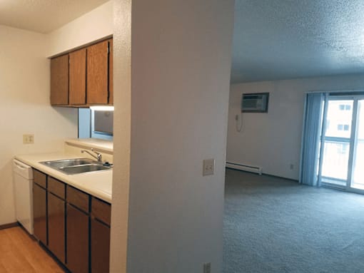 A kitchen with brown cabinets and a white sink.