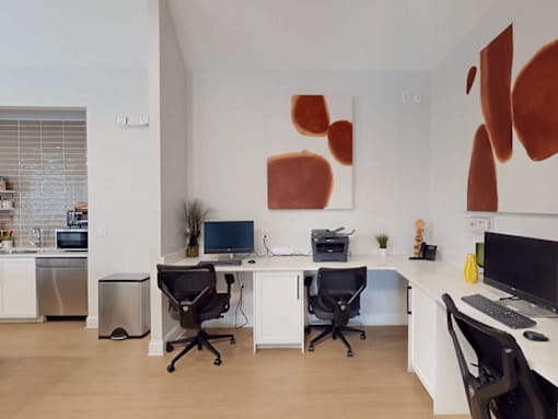 A modern home office with a large abstract painting on the wall.