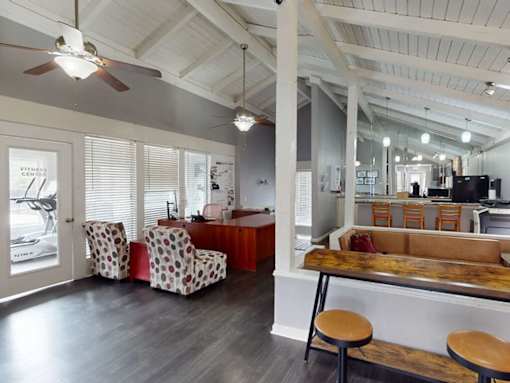 A room with a ceiling fan and a long wooden table.