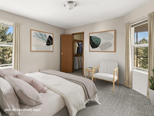 A bedroom with a large bed and a chair.