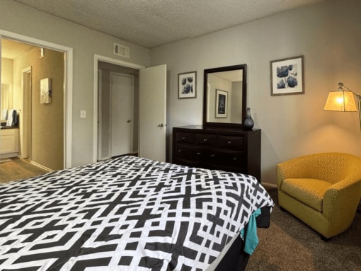 a bedroom with a large bed and a yellow chair
