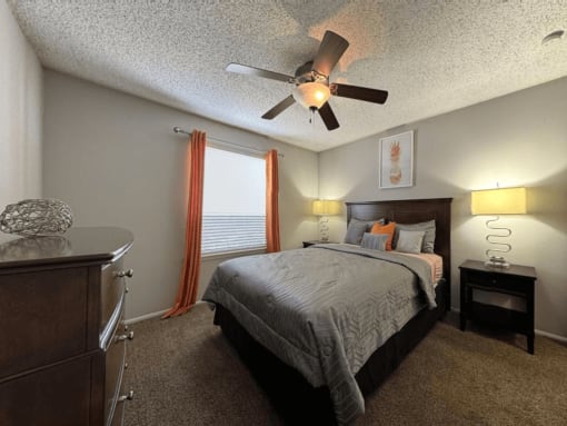 a bedroom with a bed and a ceiling fan