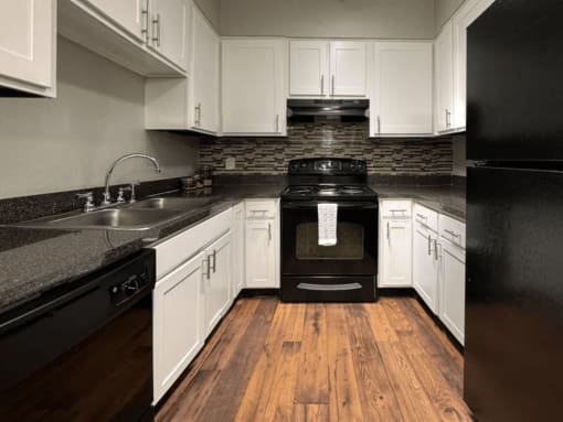 a kitchen with black appliances and white cabinets