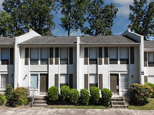 A white building with a grey roof and a blue sky in the background.