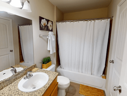 A bathroom with a sink, toilet, and shower.