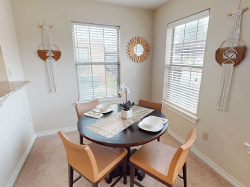 A dining room with a round table and chairs.