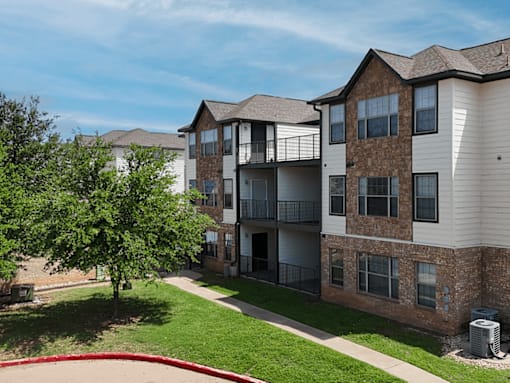Apartment complex with a red fountain in the front yard.