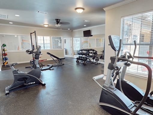 A gym with exercise equipment such as treadmills and stationary bikes.