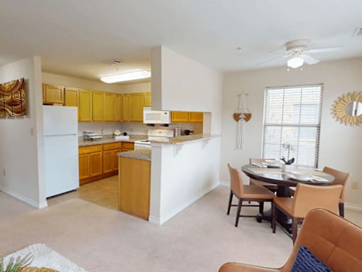 A kitchen with white appliances and wooden cabinets.