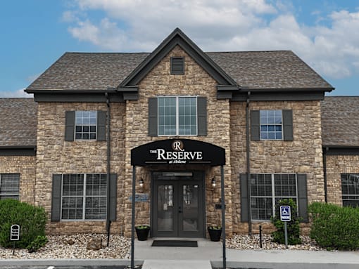A stone building with a black awning that says Reserve.