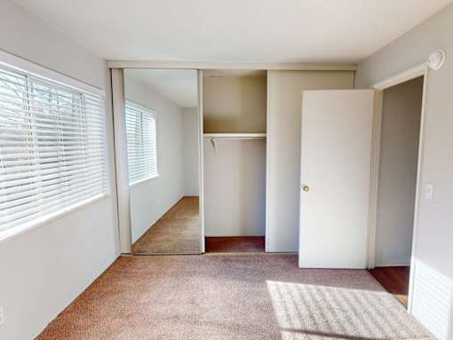 A room with a carpet, a rug, and a door.