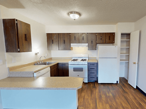 A kitchen with wooden cabinets and a white refrigerator.