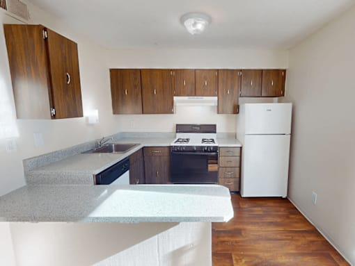 A kitchen with white appliances and wooden cabinets.